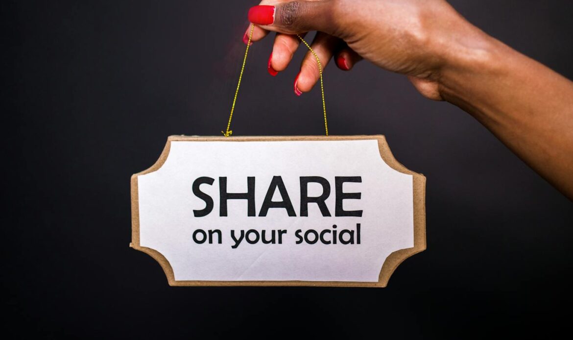 A hand holds a sign reading 'Share on your social' against a dark background.